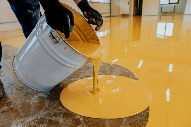 man is pouring yellow epoxy coating to replace old concrete coating in Litchfield County, CT